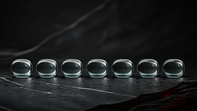 Seven identical glass forms arranged in an even row